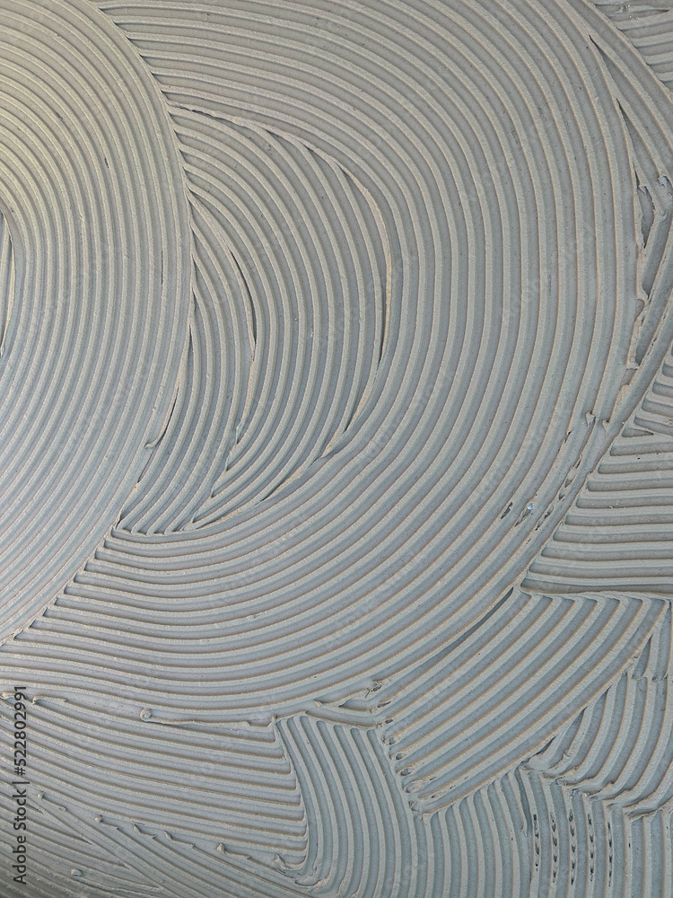 cementitious adhesive applied to the floor ready to receive the ceramic tile
