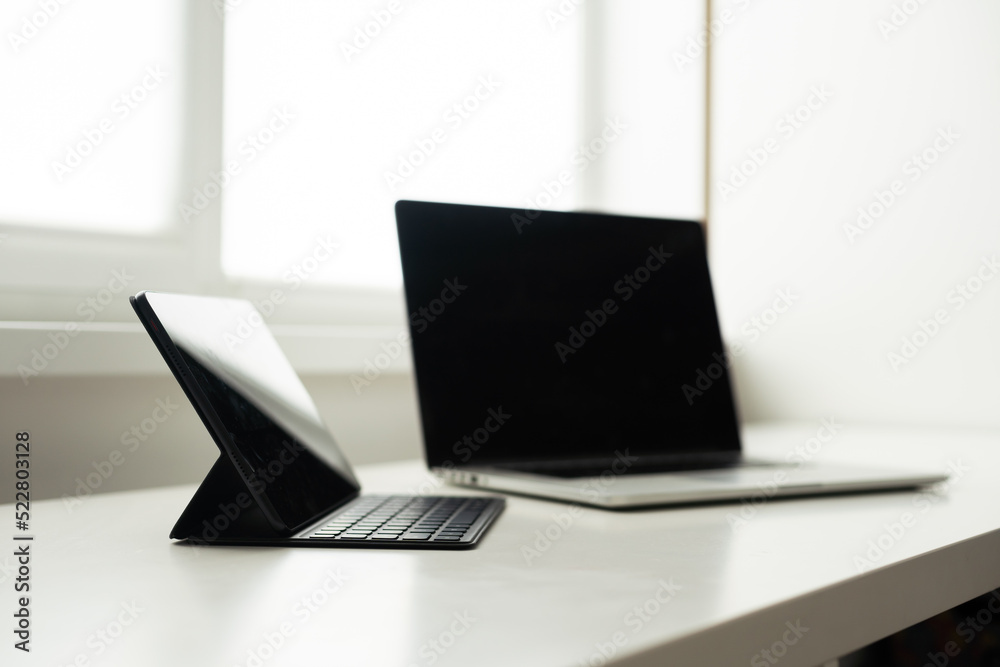 laptop and tablet on a white table. laptop and tablet on a white table.
