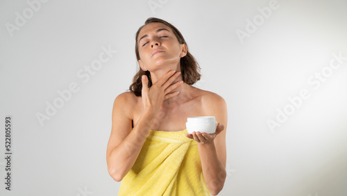 A woman applies cream to the neck - home care