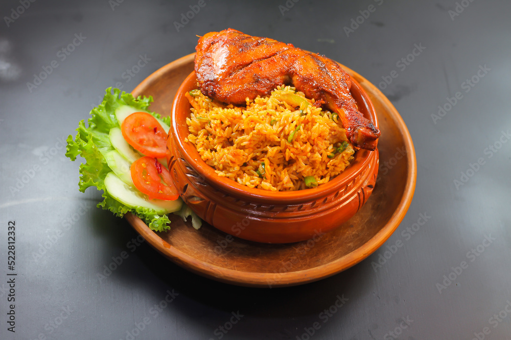 Chicken matka biryani with salad served in a matka isolated on dark background side view of indian spicy food - obrazy, fototapety, plakaty 