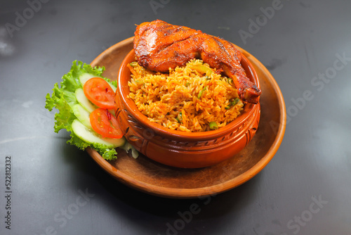 Chicken matka biryani with salad served in a matka isolated on dark background side view of indian spicy food
