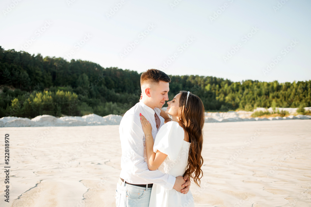 Young couple hugging on a sandy beach on a sunny day Young couple hugging on a sandy beach on a sunny day