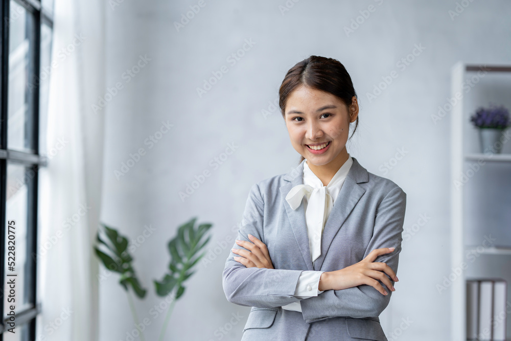 Young attractive businesswoman standing in front of a laptop with a hand holding the coffee cup and managing her small business from home. Smiling and looking at the camera. Young attractive businesswoman standing in front of a laptop with a hand holding the coffee cup and managing her small business from home. Smiling and looking at the camera.