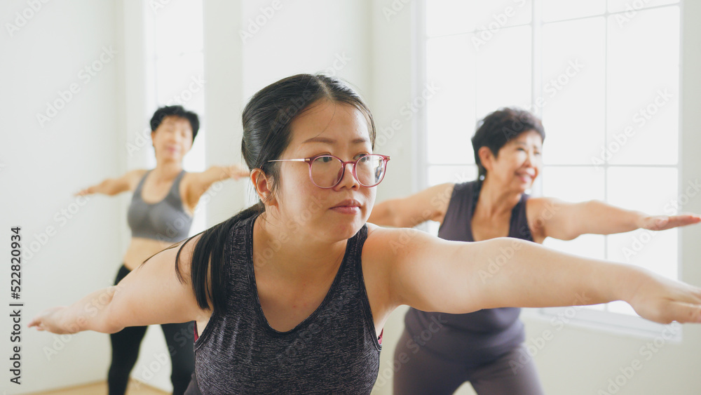 Group of Asian woman workout, exercise and practice yoga with family at gym