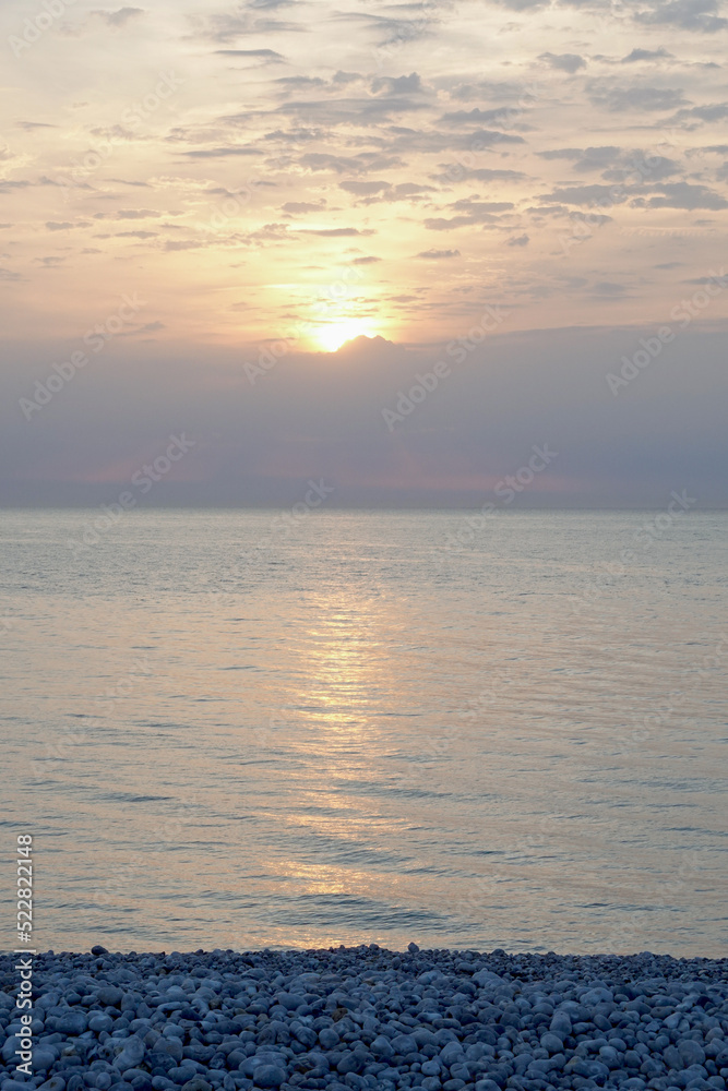 Fototapeta premium Coucher de soleil sur une plage de galets