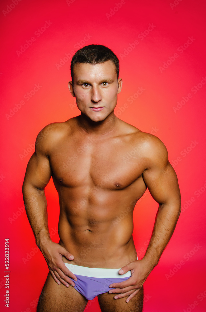 Young handsome man with athletic body posing in the studio. Sports and healthy lifestyle.	