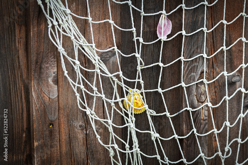 Holzwand mit Fischernetz und Muscheln, maritimer Hintergrund, Meer, Strand, Sommer Konzept