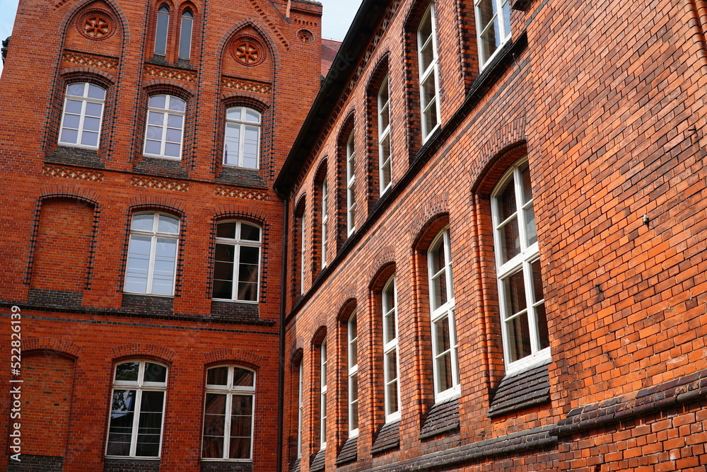 Details of a school facade in the typical North German style of brick Gothic. Small town Salzwedel, district Altmark, country Saxony-Anhalt, Germany, Europe. Details of a school facade in the typical North German style of brick Gothic. Small town Salzwedel, district Altmark, country Saxony-Anhalt, Germany, Europe.