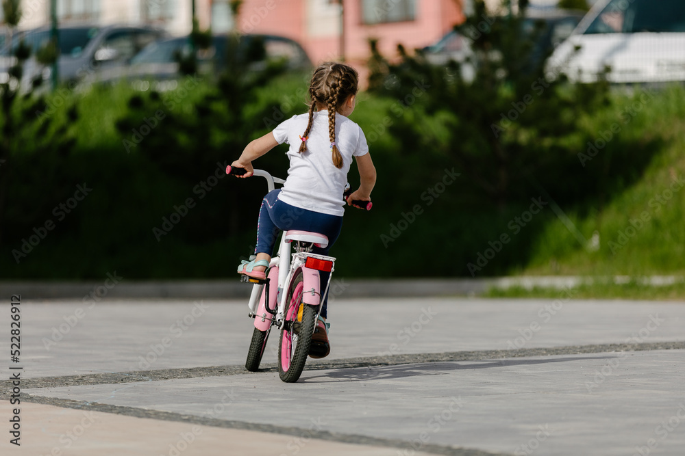 Little girl on a bicycle in summer park. cycling outdoors