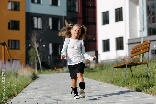 a little girl goes to school through the park along the path. distance education concept. schoolgirl returning home from school 