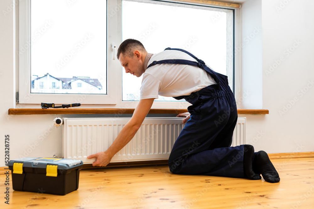 Repair heating radiator close-up. man repairing radiator with wrench. Removing air from the radiator Repair heating radiator close-up. man repairing radiator with wrench. Removing air from the radiator