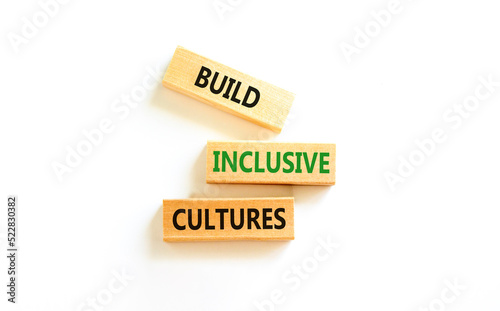 Build inclusive cultures symbol. Concept words Build inclusive cultures on wooden blocks. Beautiful white table white background. Business build inclusive cultures concept. Copy space.