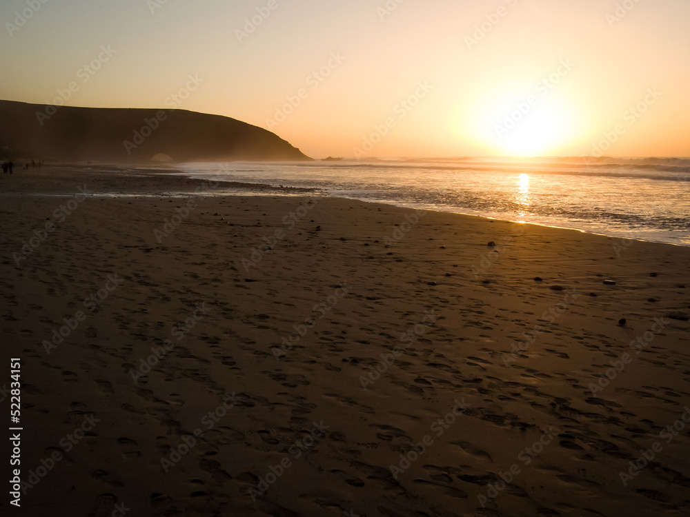 Sandy beach of Legzira in Morocco at sunset
