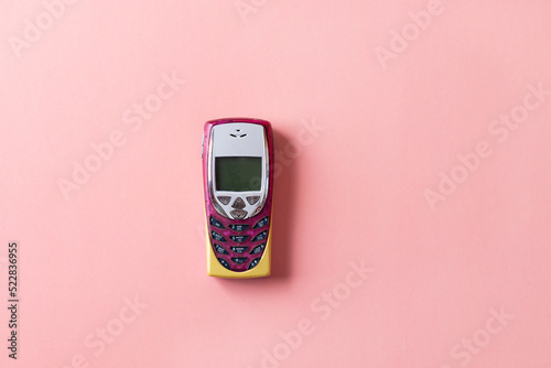 Retro mobile push-button telephone on a pink background. photo