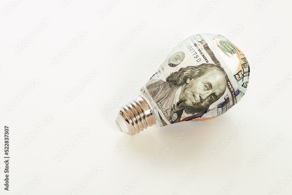100 dollar banknote wrapped light bulb on a white background. 100 dollar banknote wrapped light bulb on a white background.