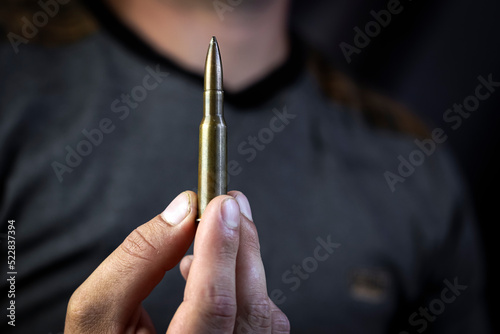 machine gun cartridge in outstretched hand, give weapons, military assistance