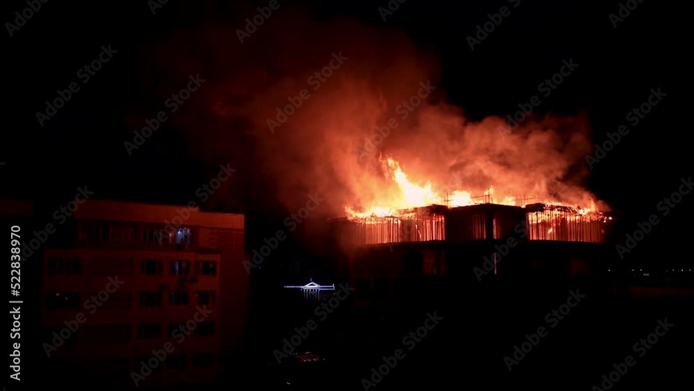 Slow motion burning fire flame on residential building roof at night