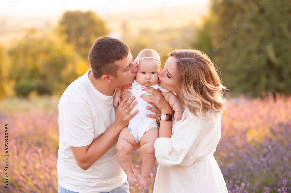 Family portrait mother father and baby on lavender field having fun together. Happy couple with child Family portrait mother father and baby on lavender field having fun together. Happy couple with child