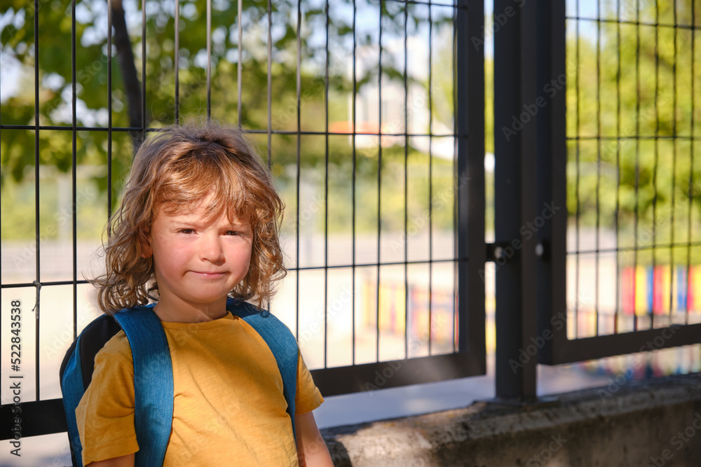 Portrait of a child with a backpack on a school wall. Portrait of a child with a backpack on a school wall.