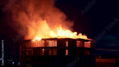 Slow motion burning fire flame on residential building roof at night