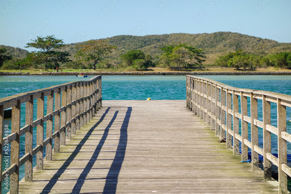 Obraz premium Perspective view of a wooden pier on tropical sea bay at sunny day