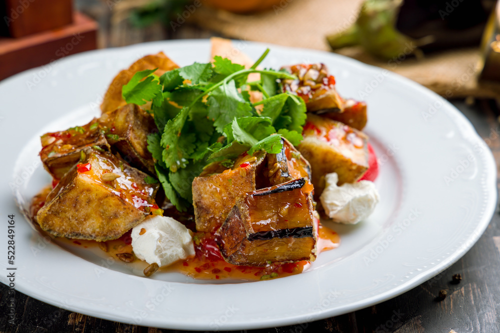 Salad with baked aubergines and feta cheese with sweet chili sauce on old wooden table Salad with baked aubergines and feta cheese with sweet chili sauce on old wooden table