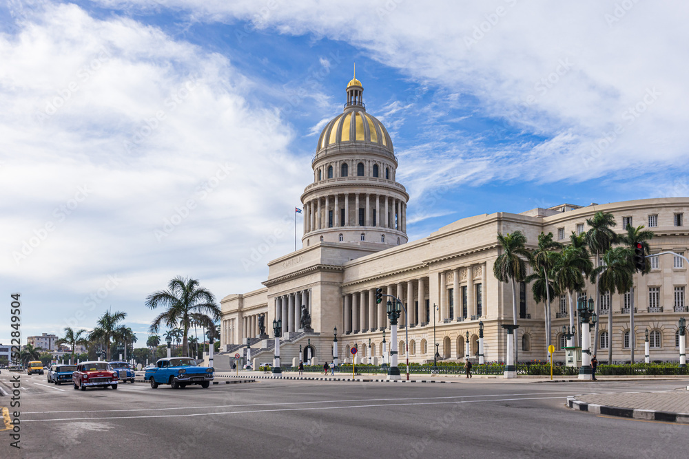 HAVANA,CUBA - JANUARY 11, 2021 : Street scene with classic convertible cars and the famous Capitol of Havana