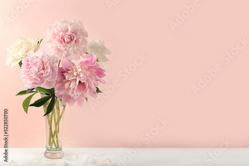 Home interior with decor elements  beautiful spring peony branches in a vase on a light background  abstract flower composition  still life with place for text  flower card for birthday