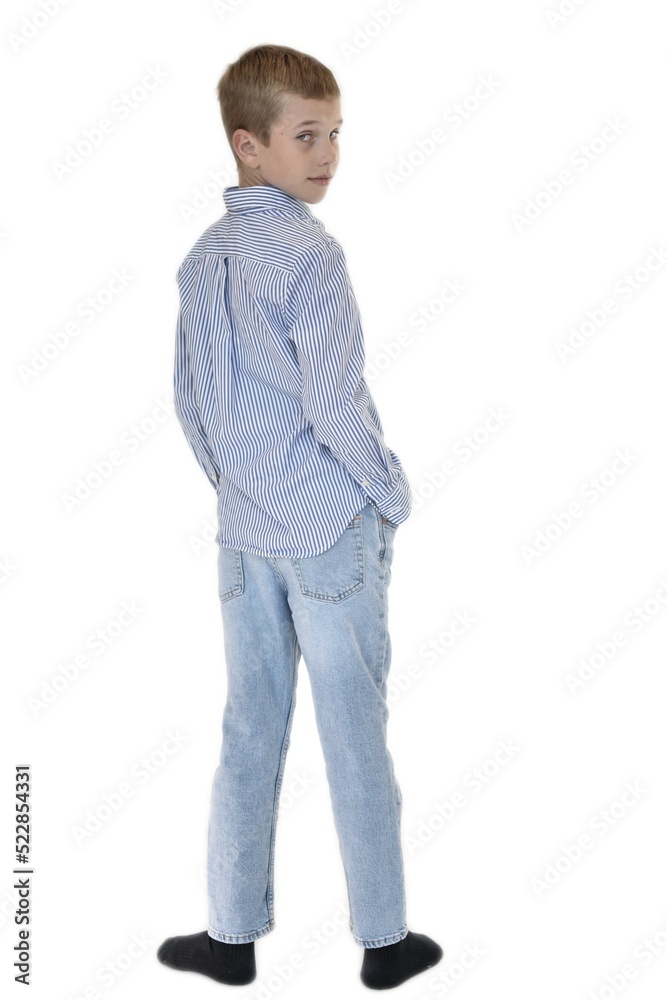 boy in jeans and a shirt stands and looks back on a white background boy in jeans and a shirt stands and looks back on a white background
