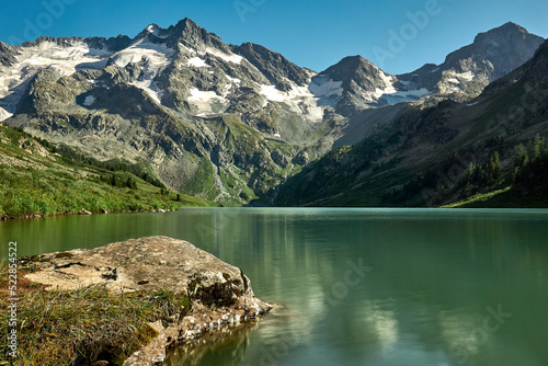 The smooth surface of a glacial lake at the foot of the Altai Mountains in the Katunsky Reserve