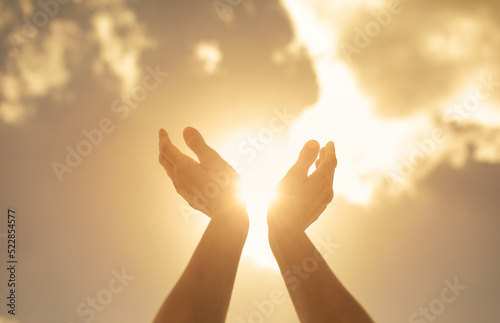 Fototapeta worshiping hands up to the bright golden sunlight