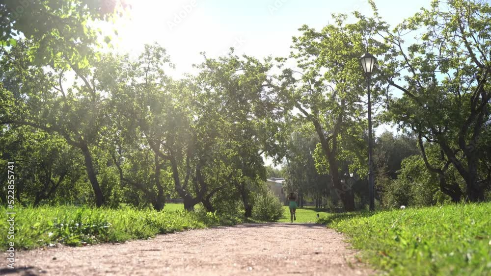 Young slim woman running, jogging training in park in sunny day summer. Leisure activity, healthy lifestyle. 4K Young slim woman running, jogging training in park in sunny day summer. Leisure activity, healthy lifestyle. 4K
