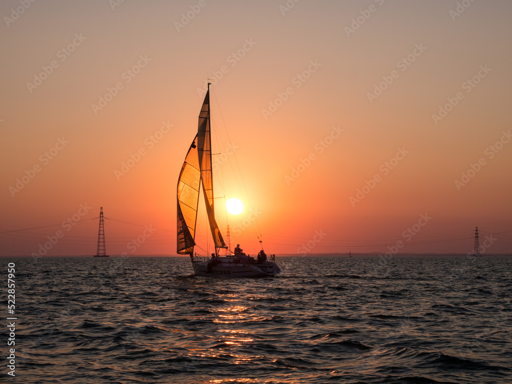 Yachts in the regatta against the backdrop of the sunset sky