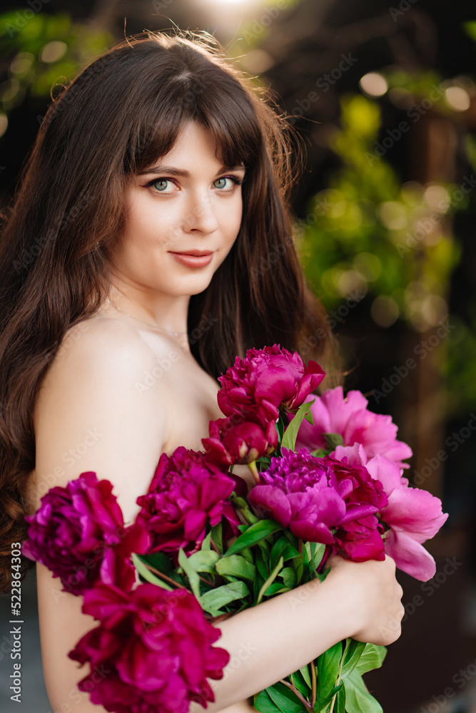 Naklejka premium an beautiful woman with long hair and bare shoulders and a bouquet of peonies