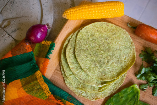 Tortillas de nopal con elote, chile y cilantro alrededor.  photo