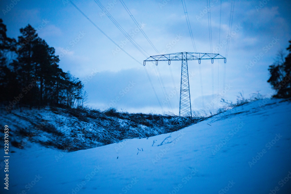 Stromtrasse im Wald im Winter am Abend Stromtrasse im Wald im Winter am Abend