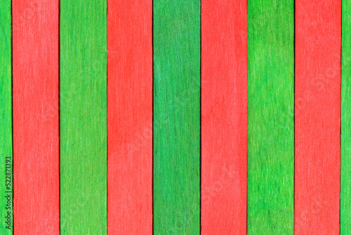 Bicolor wooden textured background in red and green colors. Alternating wooden painted boards arranged vertically. Green and red Christmas wood planks background. Table top view.