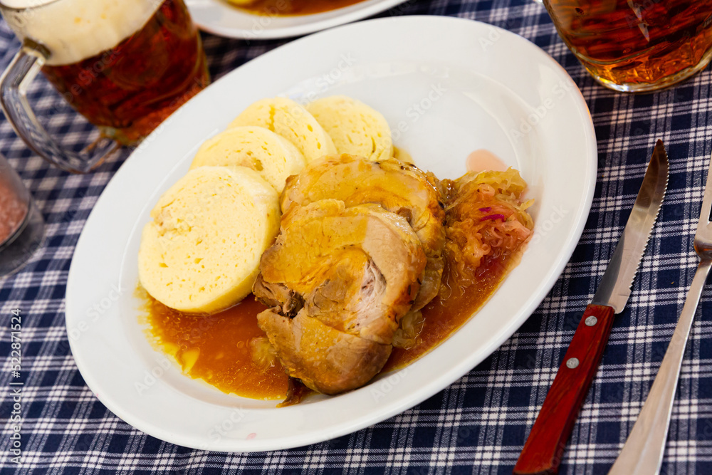 Tasty dumplings (knedliky) served with stewed pork meat in gravy and pickled cabbage. Traditional Czech dish