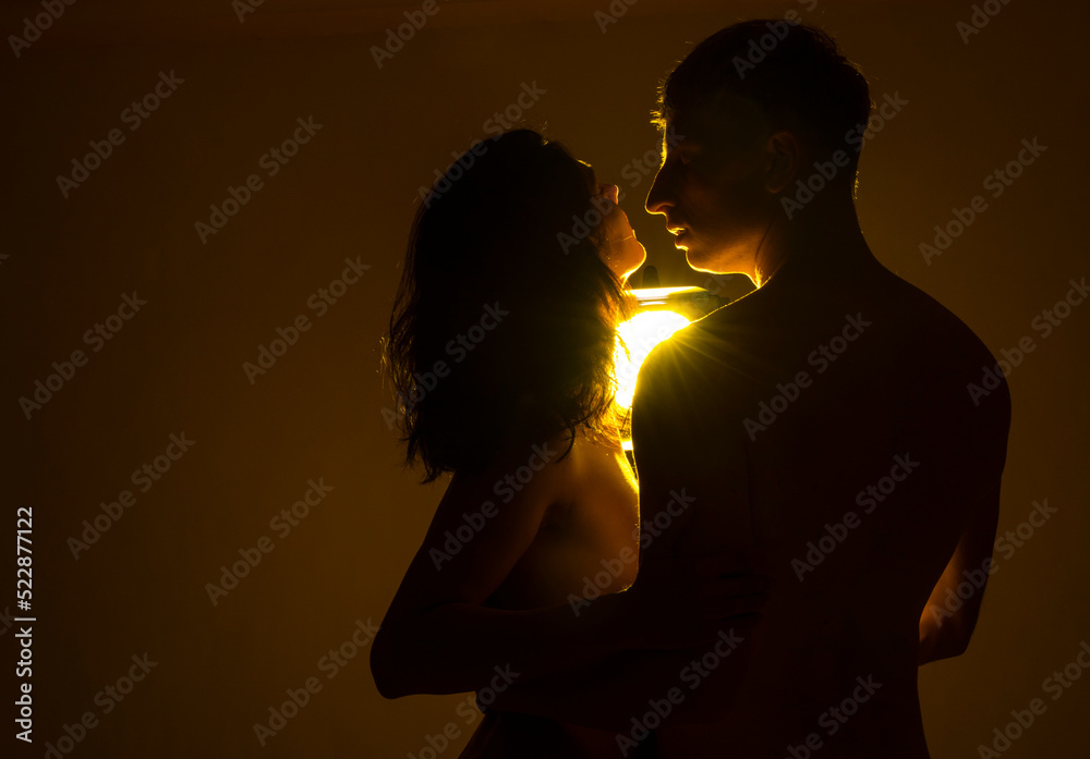 silhouette of a couple kissing. Kissing. Man and woman posing studio. Light. Erotica. Life. Kiss. 