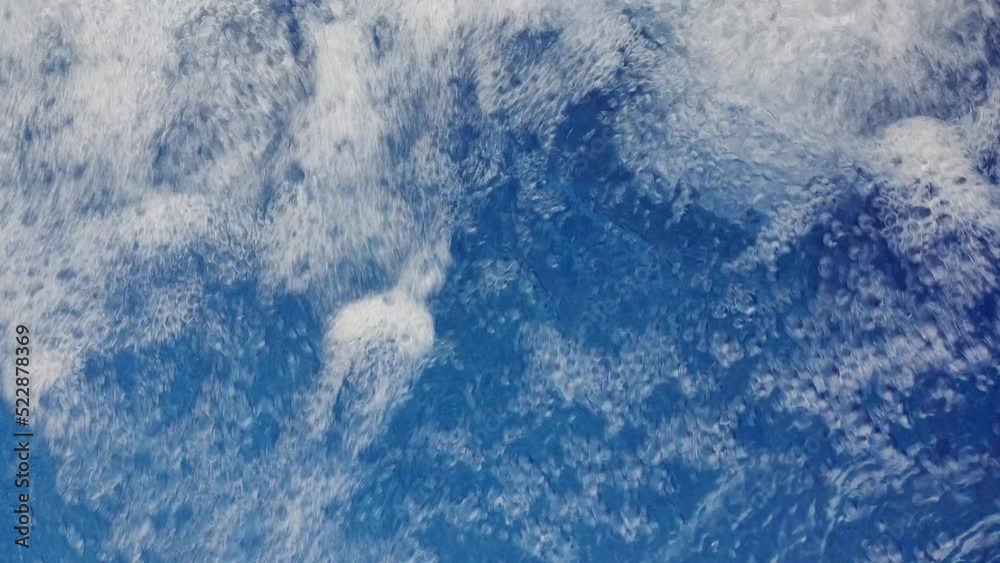 Close up de uma queda de água formando muitas bolhas de água azul em uma superfície com som para filmagens, fundos e gráficos, longa duração 4K 30FPS.