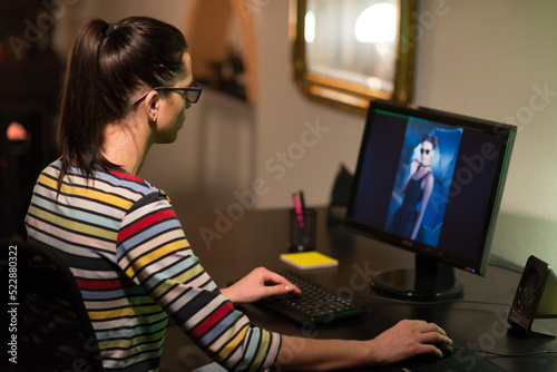 Young woman browsing through her modeling photos on the computer monitor