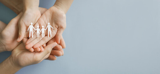 Hands holding paper family cutout,,adoption foster care, lgbt family mental health, life insurance. volunteer community concept