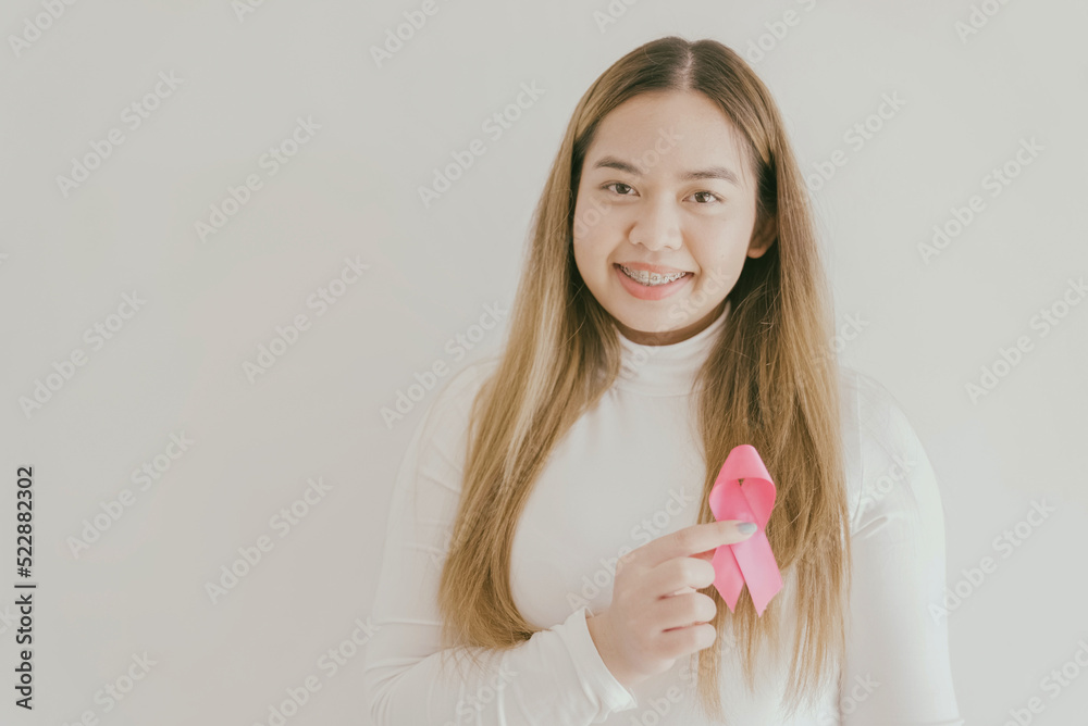 Young Asian woman with pink ribbons, breast cancer awareness, October pink concept, world cancer day Young Asian woman with pink ribbons, breast cancer awareness, October pink concept, world cancer day