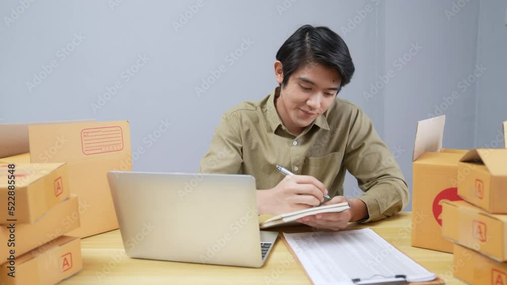 Business concept of 4k Resolution. Young Asian man checking online customer orders in office. Business concept of 4k Resolution. Young Asian man checking online customer orders in office.