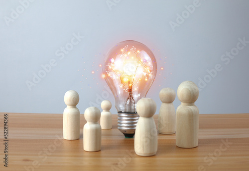 A light bulb and a wooden doll on the desk,New technologies, big data, and business process strategies, innovative solutions,new idea.