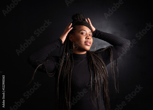 stylish portrait of a young and beautiful afro american woman with long braided hair and black outfit. High quality photo