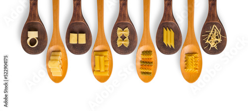 Wooden cooking spoons filled with various types dry pasta