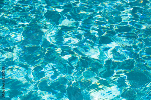 Background of blue water in swimming pool with sun reflection  ripple water wave in pool. Clear water background.
