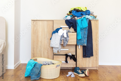 chest of drawers, with clothes in mess, a basin for collecting linen for washing