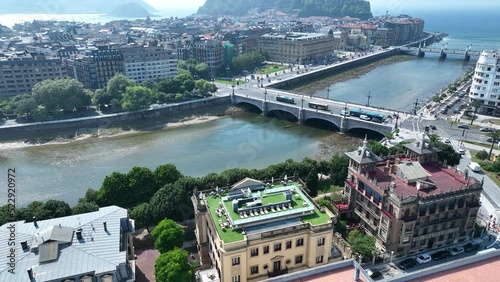 Aerial drone shot of the Urumea River and the Santa Catalina Zubia Bridge arcing around to reveal the Bay of Biscay and the coastal city of San Sebastian, Basque Country photo